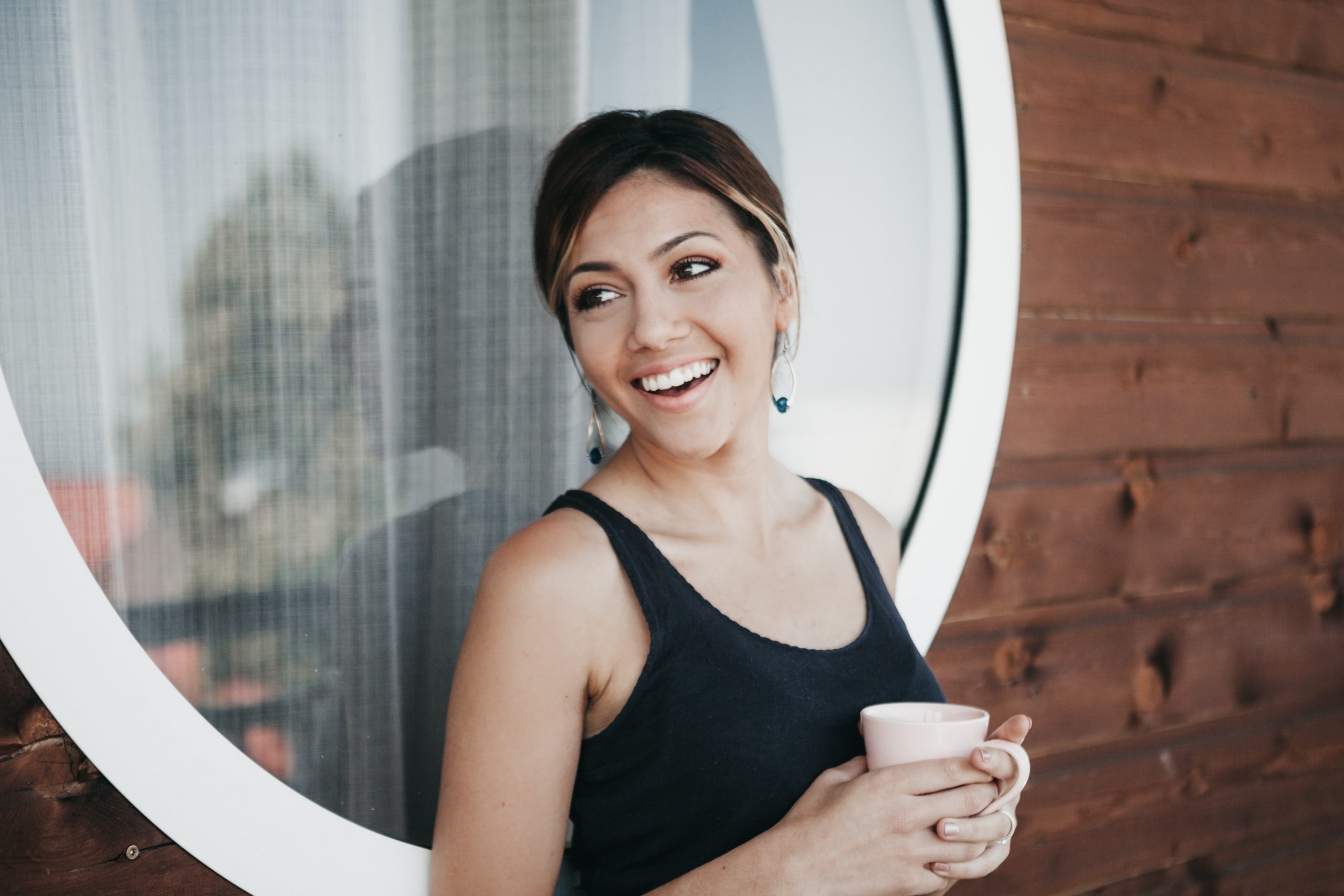 a hispanic woman holding a cup of coffee