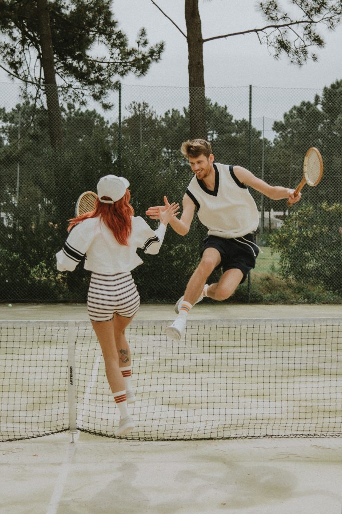 man and woman high fiving after a tennis match