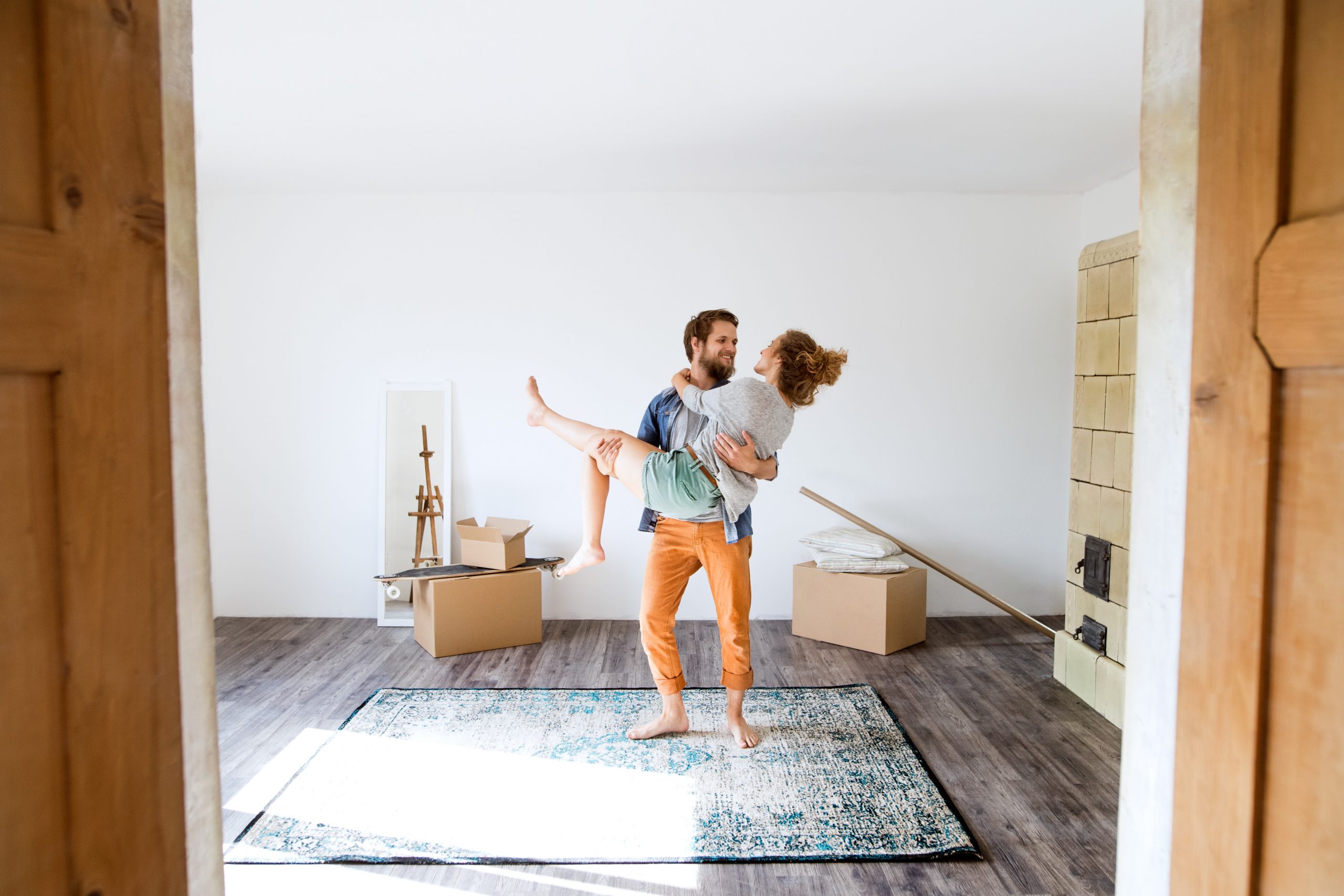 man holding a woman in their new home